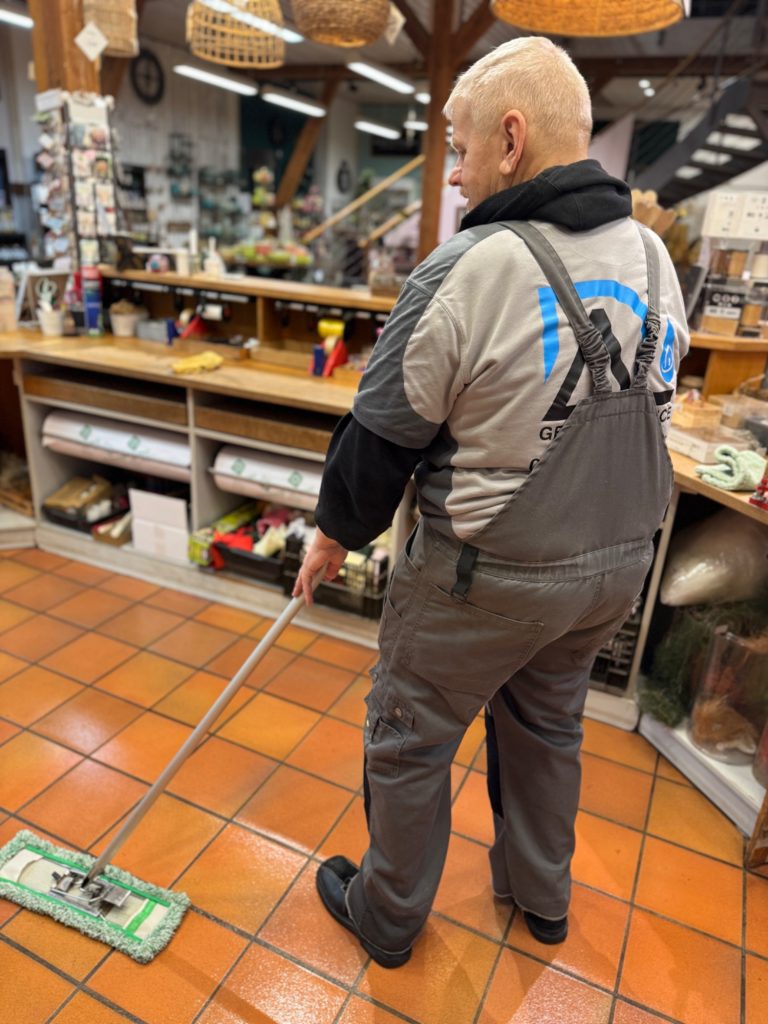 Unterhaltsreinigung & Ladenreinigung Nagold Reinigungskraft bei der Bodenreinigung in einem Ladengeschäft in Nagold.