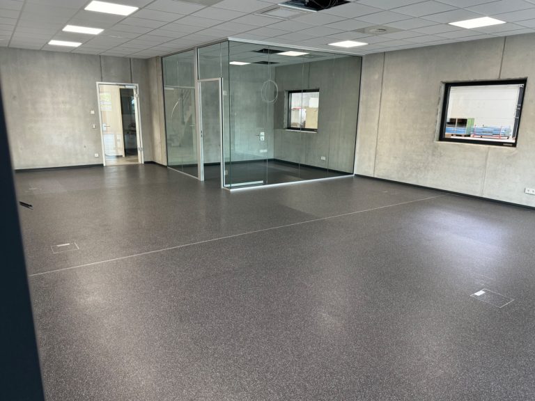 Ergebnis Grundreinigung - Elastischer Bodenbelag im Büro Strahlend sauberer elastischer Bodenbelag in einem modernen Büro mit Glastrennwänden nach der professionellen Grundreinigung.
