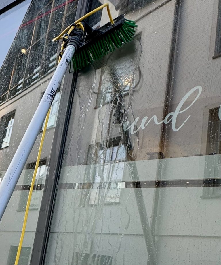 Reinwasser-System für hohe Fenster Glasreinigung mit wasserführender Teleskopstange und Reinwasser-System an einer hohen Hausfassade in Herrenberg.