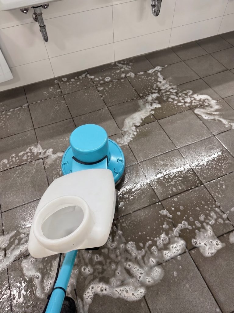 Fliesenreinigung mit Einscheibenmaschine Grundreinigung von Fliesenboden mit einer Einscheibenmaschine und Reinigungsschaum.